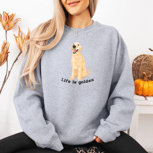 A woman wearing a sweatshirt in color sport grey with a golden retriever and a text "Life is Golden" from Love Dogs Gifts store