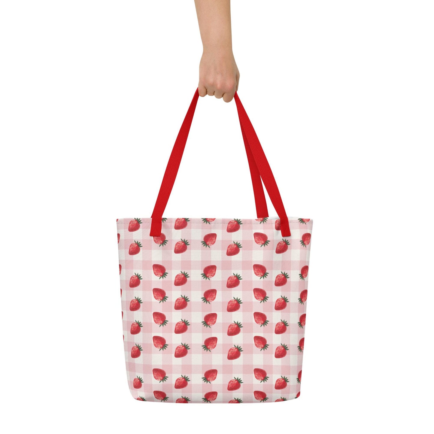 A hand holding a Strawberry Summer Tote Bag