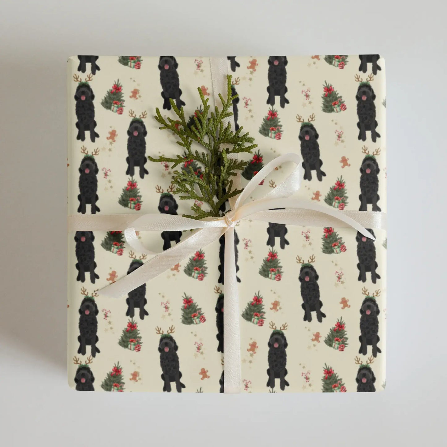 Christmas wrapping paper with black goldendoodle patterned and xmas tree with presents paper on a cream background