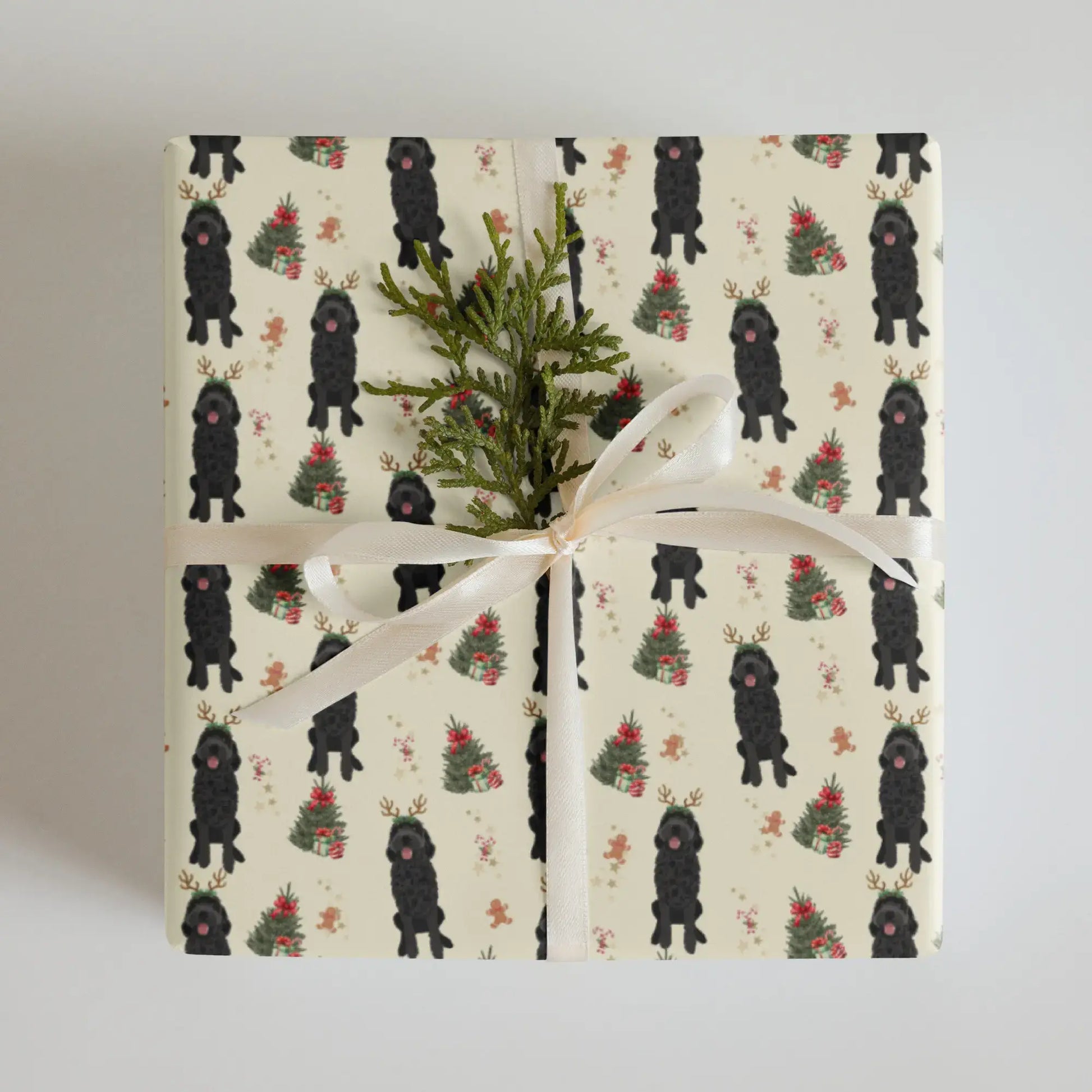 Christmas wrapping paper with black goldendoodle patterned and xmas tree with presents paper on a cream background