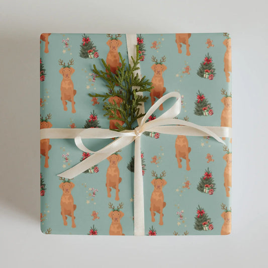 Gift wrapped in Christmas wrapping paper with Vizslas and Christmas trees on a sage color background.