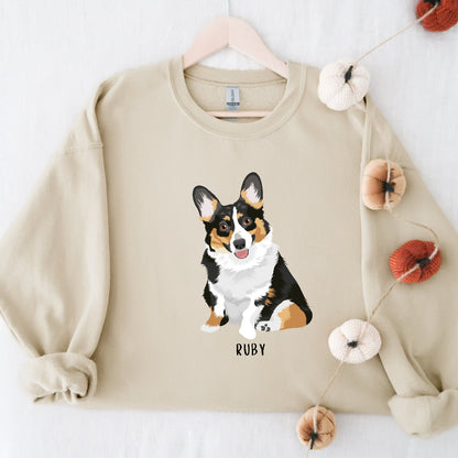 Sand color sweatshirt with a tri-color corgi graphic and personalized dogs name from Love Dogs Gifts
