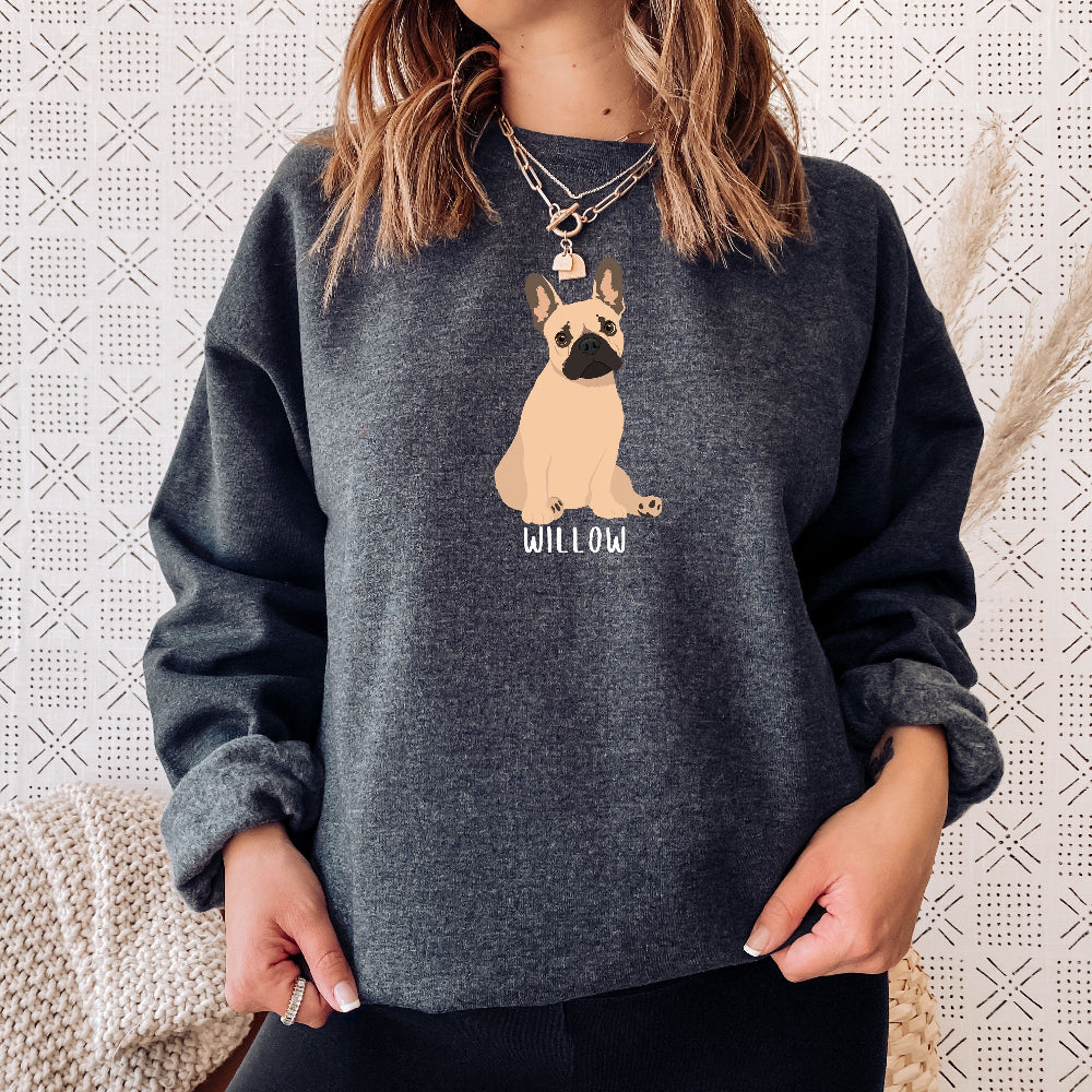 A dog person wearing a personalized French Bulldog sweatshirt  in color dark heather with a tan frenchie, and a dogs name underneath the dog graphic