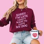 A dog mom wearing a sweatshirt in color burgundy with the lavander colored text "Sorry I'm Late I Didn't Want to Leave My Dog" from Love Dogs Gifts