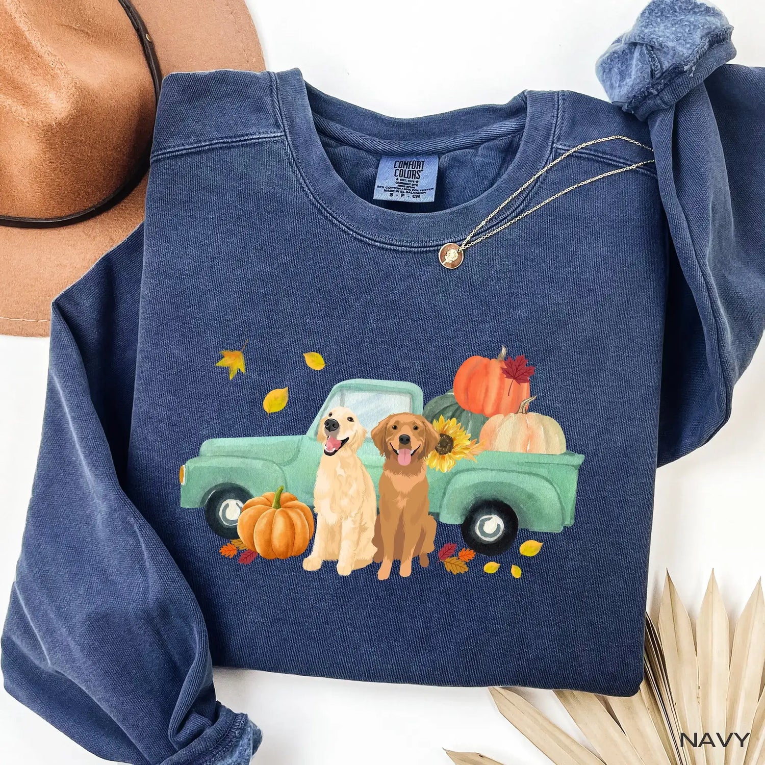 Navy comfort colors sweatshirt with a graphic of two golden retrievers next to a truck with pumpkins and leaves.