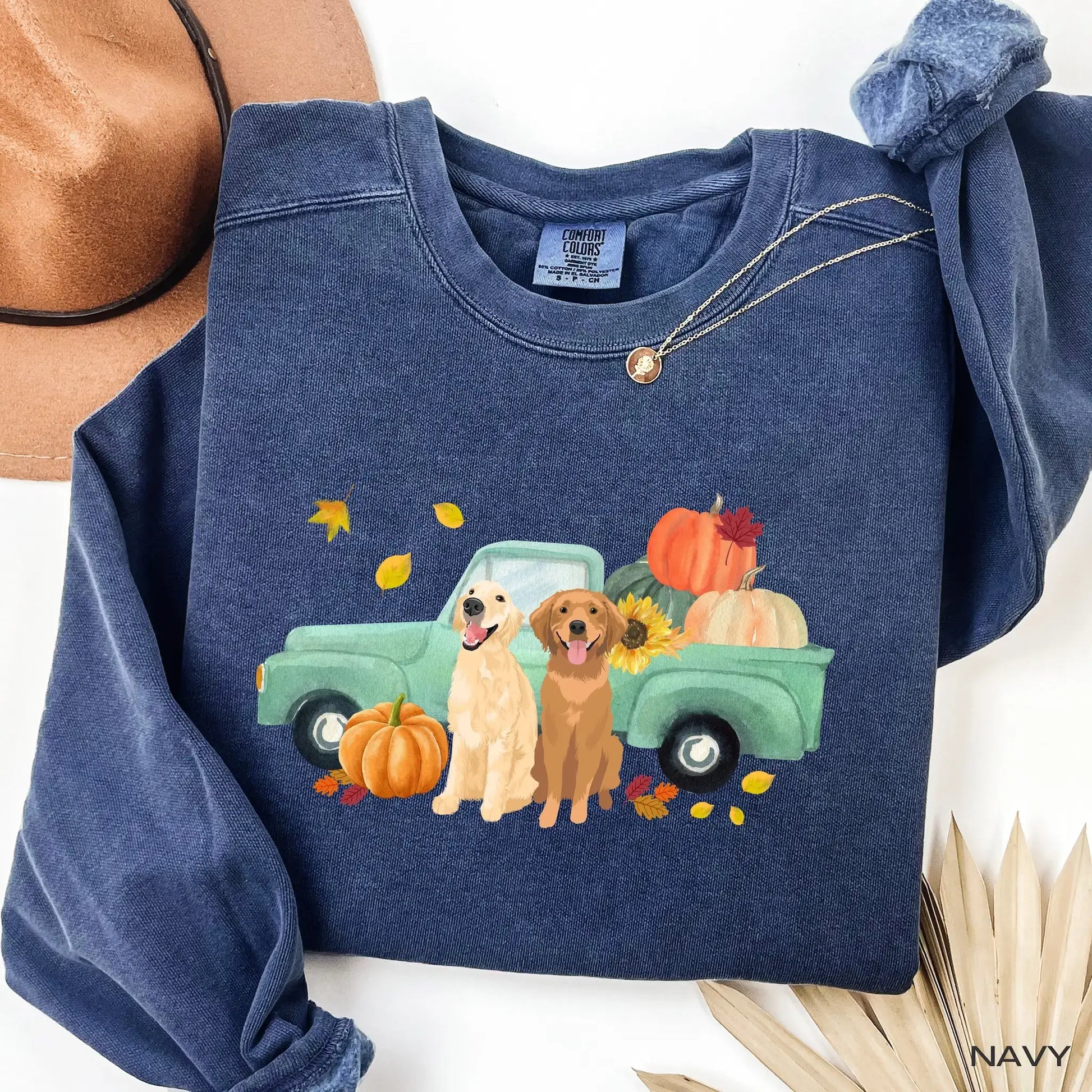Navy comfort colors sweatshirt with a graphic of two golden retrievers next to a truck with pumpkins and leaves.