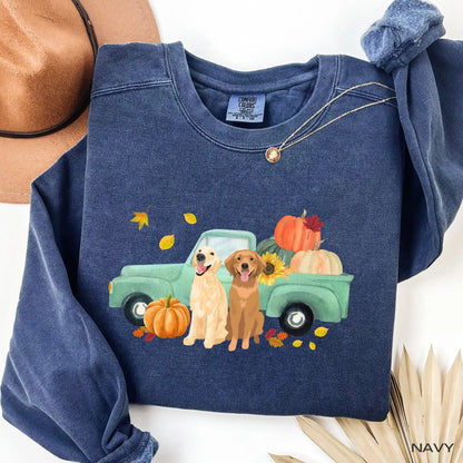 Navy comfort colors sweatshirt with a graphic of two golden retrievers next to a truck with pumpkins and leaves.