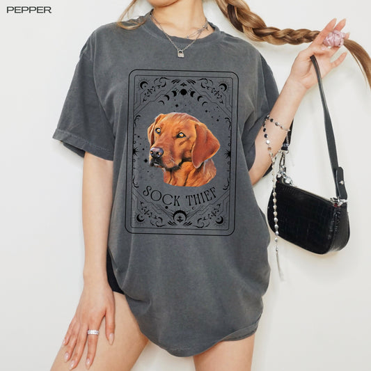 A woman wearing a tarot inspired red fox Labrador retriever dog shirt and holding her braid in one hand