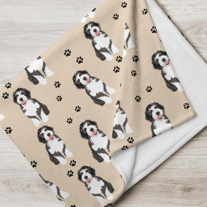 flatlay view of a Bernedoodle print blanket with dog paws