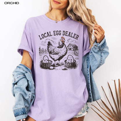 Local egg dealer comfort colors 1717 orchid t-shirt on a woman&#39;s body with a denim jacket.