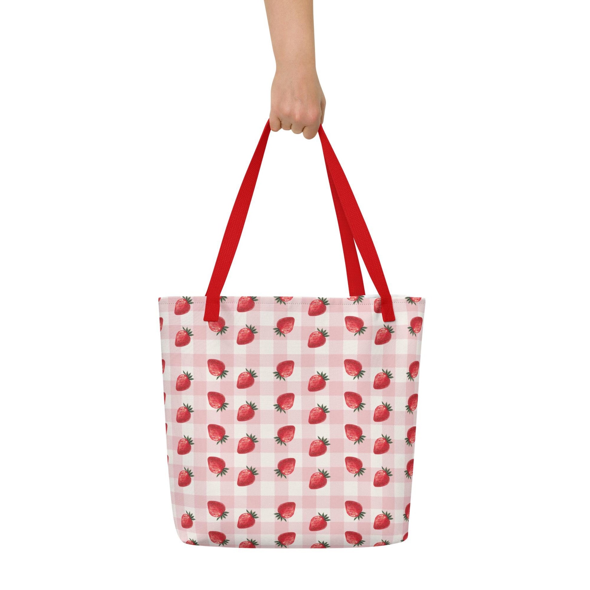 A hand holding a Strawberry Summer Tote Bag