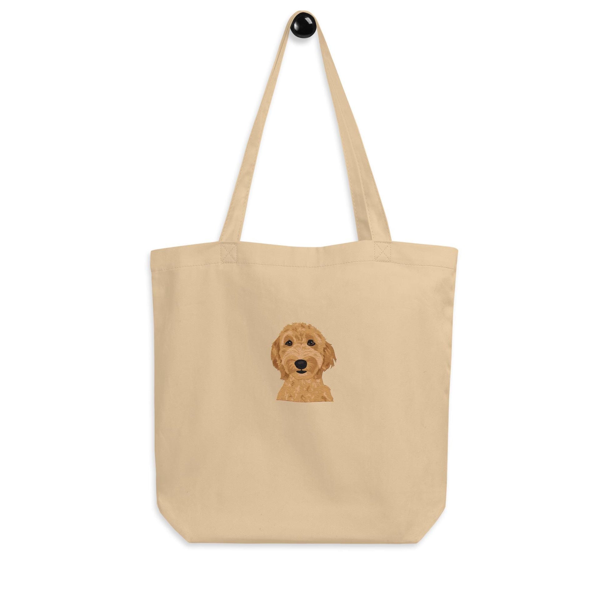 Embroidered Goldendoodle eco tote bag hanged on a hook