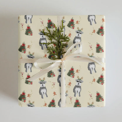 Gift wrapped in a Christmas wrapping paper with dogs, miniature schnauzer and Christmas tree pattern on a neutral background